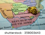 Close-up of a gold nugget on top of a map of South Africa