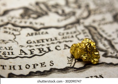 Close-up Of A Gold Nugget On Top Of An Old Map Of Africa