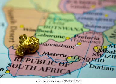 Close-up Of A Gold Nugget On Top Of An Old Map Of South Africa