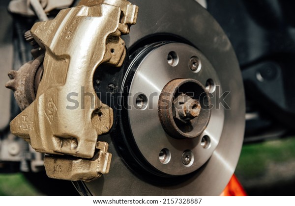 A closeup of Gold painted  car brake calipers and\
brake discs