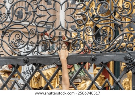 Close-up of the gold ring within the latticework of the Schoner Brunnen, or Beautiful Fountain in Nuremberg, Germany. It is a tradition to turn the gold ring to bring good luck and fortune.