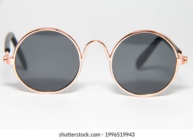 A Close-up Of Gold-framed Round Sunglasses. White Background.