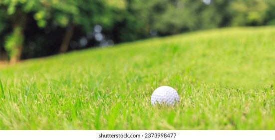 Close-up of Golf ball on the grass green at the sloping golf course