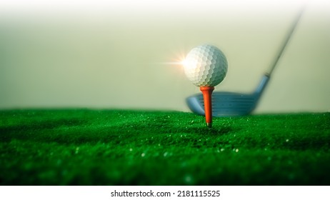 Close-up of a golf ball on the hitting platform Golf ball on red platform on green grass and golf club in the back ready to hit.Sports and health concept - Shutterstock ID 2181115525