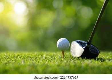 Close-up golf ball on tee with golf drivers at golf course.