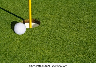 Close-up Of Golf Course Green, Flag Pin And Ball.