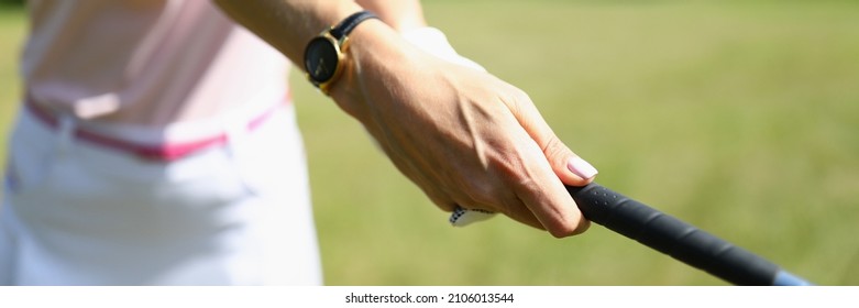 Close-up of golf player with driver teeing-off in tournament competition. Golf course for winner. Comfy outfit and perfect grass field. Sport game and woman champion concept