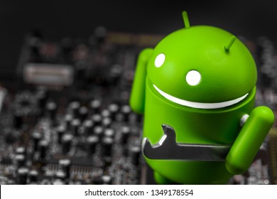 closeup Google Android figure with wrench on the circuit board. Google Android is the operating system for smartphones, tablet computers, e-books, and other devices. Moscow, Russia - March 17, 2019