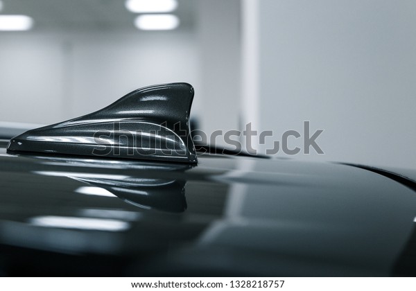 Close-up GPS antenna shark fin shape on a roof of car
for radio navigation system. Antenna shark fin on blurry
background. Car detail
