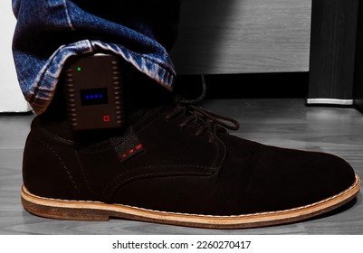 A close-up of a GPS tracking device on a man's leg, used by the police to monitor violent people - Shutterstock ID 2260270417