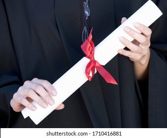 Gros plan sur un diplômé détenant un diplôme : photo de stock