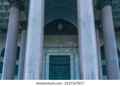 Close-up of a grand entrance featuring towering columns and an ornate bronze door, exemplifying neoclassical architecture and cultural heritage. The scene captures architectural grandeur - Powered by Shutterstock