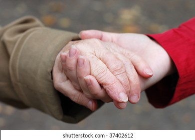 Closeup Of A Grandfather Holding His Grand Daughter Hand