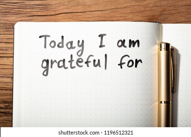 Close-up Of Gratitude Word With Pen On Notebook Over Wooden Desk - Shutterstock ID 1196512321