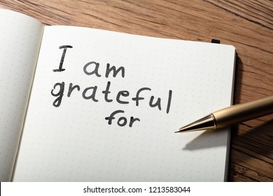 Close-up Of Gratitude Word With Pen On Notebook Over Wooden Desk - Shutterstock ID 1213583044
