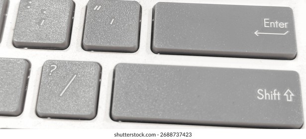 Close-up of gray computer keyboard keys showing Enter and Shift buttons, representing technology, digital communication, and modern workspace concepts.