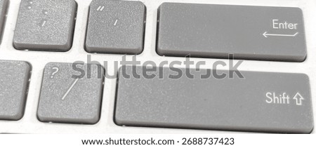 Close-up of gray computer keyboard keys showing Enter and Shift buttons, representing technology, digital communication, and modern workspace concepts.