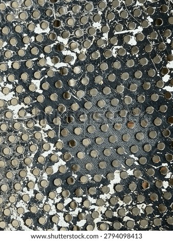 Close-up of a gray and white textured surface with numerous small circular indentations.