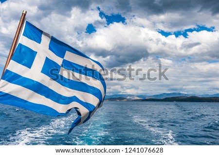 Closeup of a Greek flag waving on on stern of the ship.  