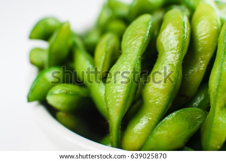 Closeup of green beans in a white bowl isolated on a white background. Top view