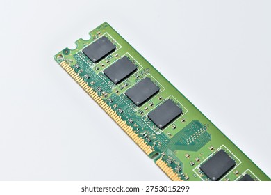 Close-up of a green computer RAM module with black memory chips on a white background
