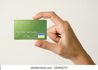 closeup of green credit card holded by hand.