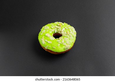 Close-up Of Green Doughnut Or Donut Isolated On A Black Background. Food Background.