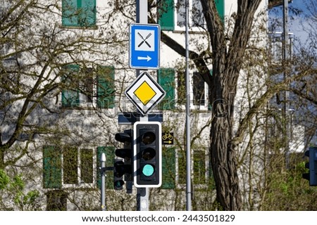 Close-up of green light at traffic light with road signs at Swiss City of Zürich on a cloudy spring day. Photo taken March 23rd, 2024, Zurich, Switzerland.