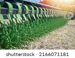 Closeup of a green spoked harrow for cultivating land in a field. Against the backdrop of a tractor.