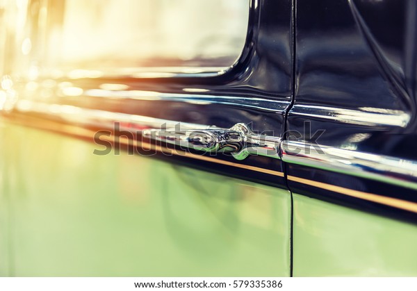 Closeup of a green\
vintage car in sunlight