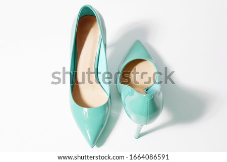 Closeup green women patent leather shoes isolated on white background. Stilettos shoe type. Summer fashion and shopping concept. Luxury and glamour party ladies wardrobe accessory. Selective focus
