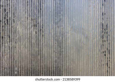 Close-up of a greenhouse wall made of old worn out dirty polycarbonate. Close up of old roof full of holes polycarbonate