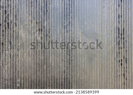 Close-up of a greenhouse wall made of old worn out dirty polycarbonate. Close up of old roof full of holes polycarbonate