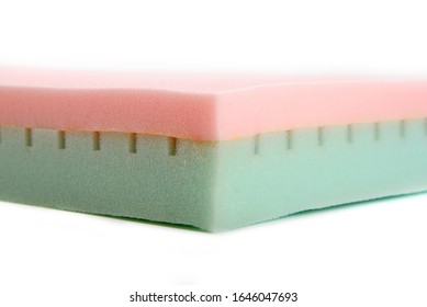 Close-up of green-pink comfortable medical foam sleeping mattress on white background