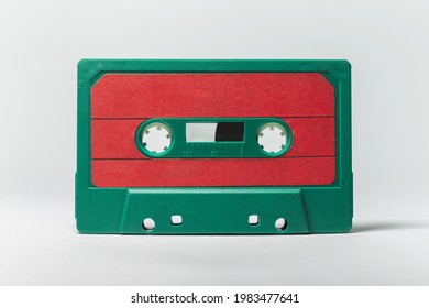 Close-up Of Green-red Vintage Music Cassette On White Background. Studio Object Image.