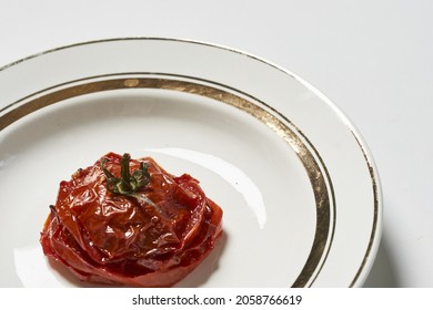 A Closeup Of Grilled And Smashed Tomato On A Plate