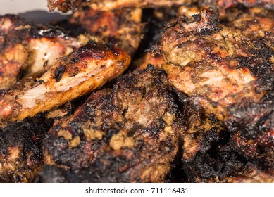 Closeup of grilled  spicy jerk chicken cooked over wood  fire.