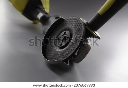 Close-up of grinder instrument for metal works, electrical saw on grey background. Circular saw equipment for construction works. Carpentry, handy concept