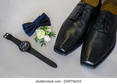 Close-up of the groom's accessories: bow tie, leather shoes, boutannie, watch. Groom's wedding set. Stylish business clothes.Close-up.Wedding day. - Powered by Shutterstock