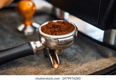 Close-up of ground coffee in portafilter or portable coffee filter handle and ground coffee for a coffee making machine - Powered by Shutterstock