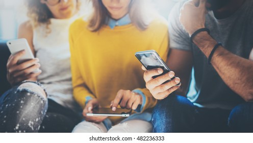 Closeup Group Adult Hipsters Friends Sitting Sofa Using Hands Modern Smartphone Tablet.Business Startup Friendship Teamwork Concept.People Working Together Project.Coworking Process Studio.Blurred - Shutterstock ID 482236333