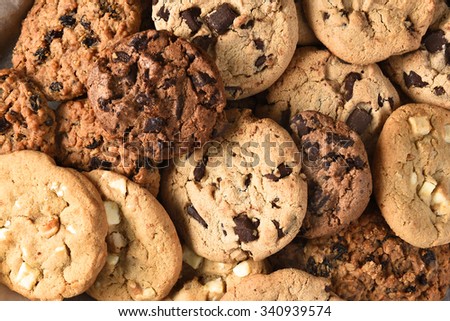 Closeup of a group of assorted cookies. Chocolate chip, oatmeal raisin, white chocolate fill the frame.