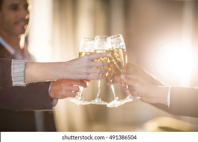 Close-up of group of businesspeople toasting glasses of champagne in the office - Powered by Shutterstock