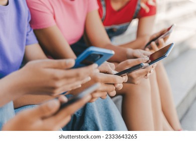 Closeup, group of teenagers holding mobile phones watching video, communication online, chatting, selective focus. Children playing mobile game on smartphones.  Technology, social media concept - Powered by Shutterstock