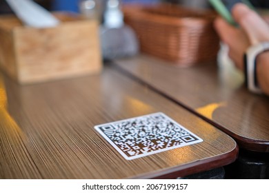 Closeup Of Guest Hand Ordering Meal In Restaurant While Scanning Qr Code With Mobile Phone For Online Menu.