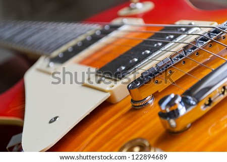 closeup of a guitar bridge with control knobs
