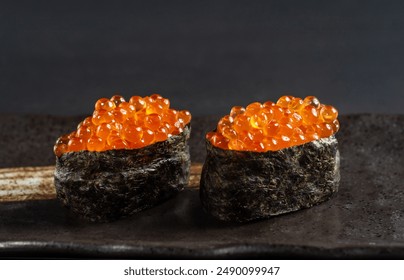Close-up Gunkan Maki Sushi with salmon caviar (Ikura) On a beige Japanese plate with copy space for your text. - Powered by Shutterstock