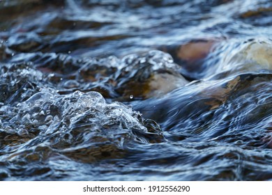 Closeup of Gurgling Water over Cobblestone in a River - Shutterstock ID 1912556290