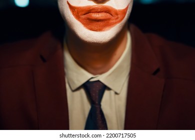 Close-up Of A Guy's Mouth With Joker Makeup. Man In A Suit And Tie. Halloween Party.