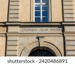 Close-up of the Gymnase Jean Sturm inscription on a classical building facade.